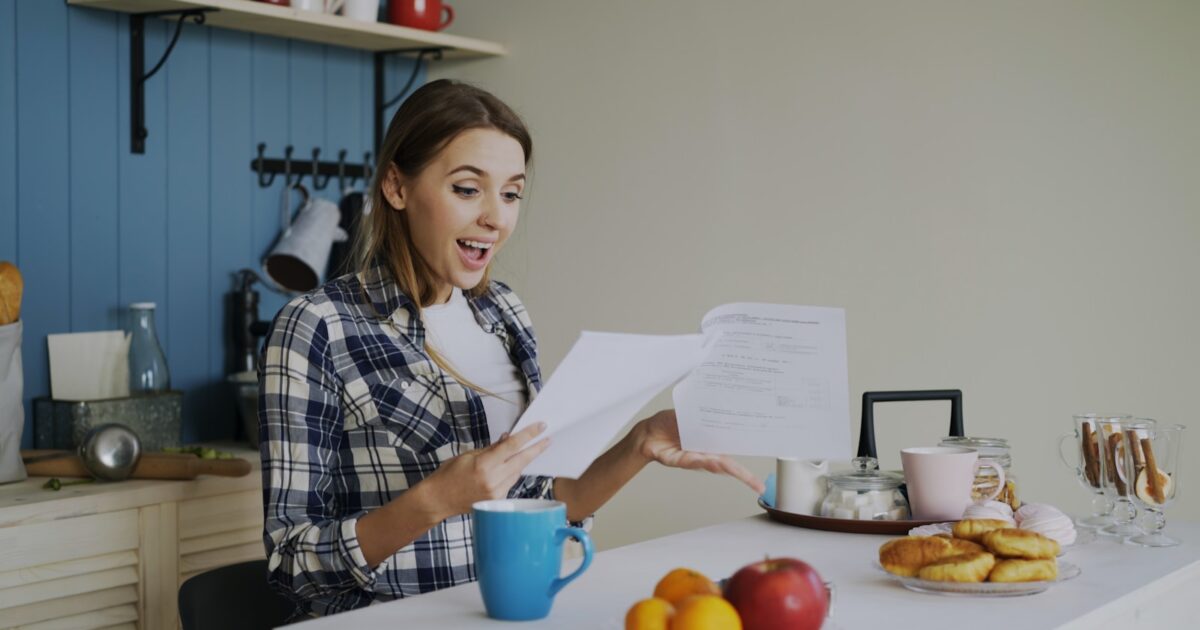 Une personne vérifie sa facture d’électricité à la table de la cuisine