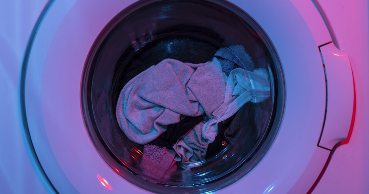 Technicien réparant un lave-linge dans un atelier de réparation d'électroménager